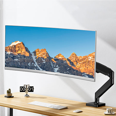 Ultrawide monitor on adjustable arm displaying mountain landscape in home office setup