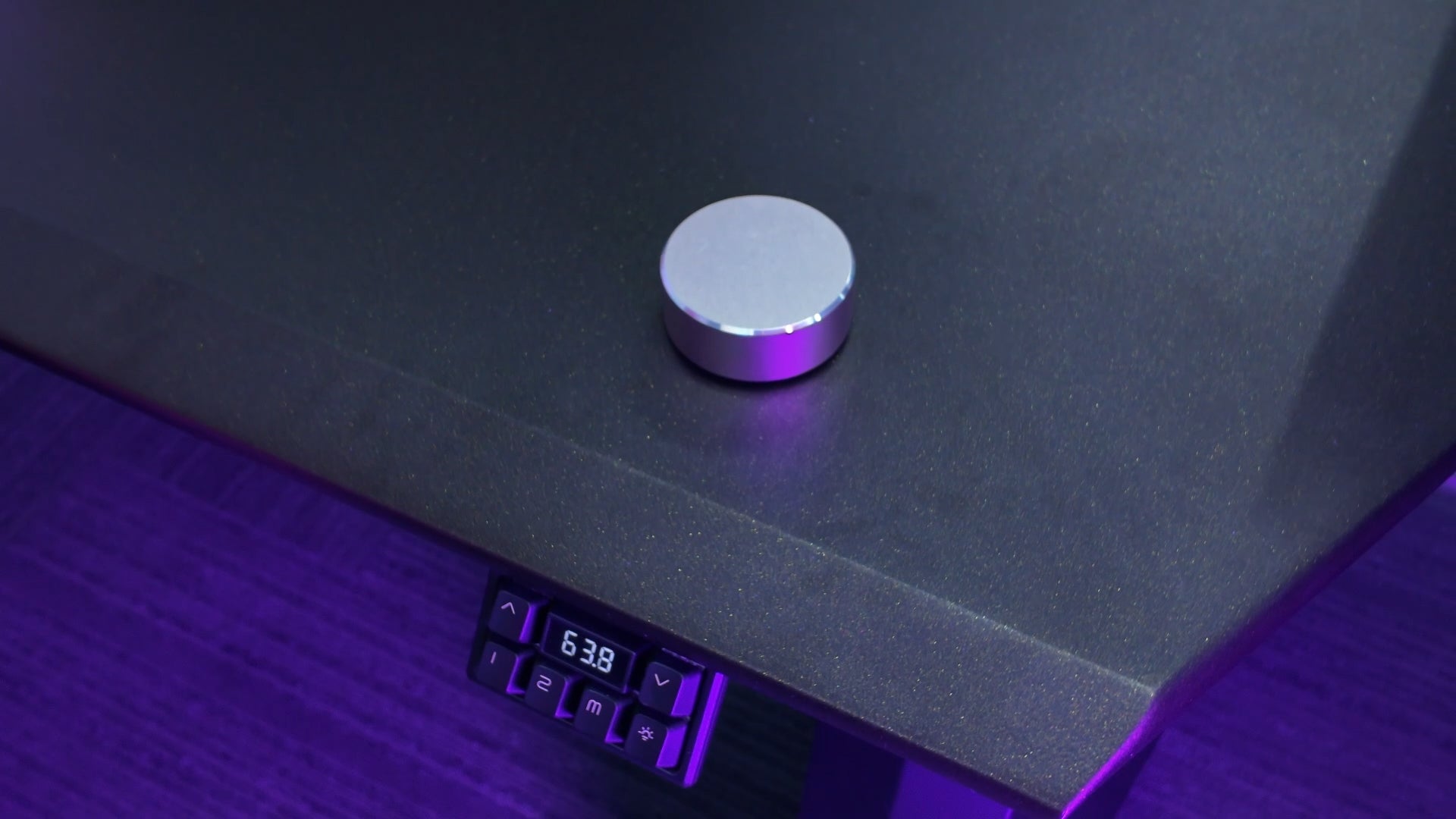 Load video: Demonstration of the wireless Bluetooth controller adjusting desk height via rotary dial.