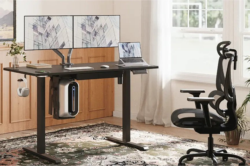 Dual monitors on an adjustable desk with an ergonomic chair for a perfect home office.