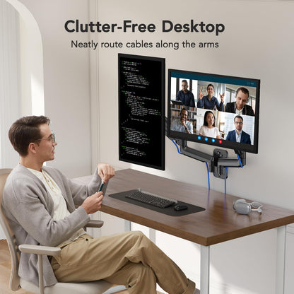 Man in a home office using dual monitors for video calls and coding, featuring cable management.