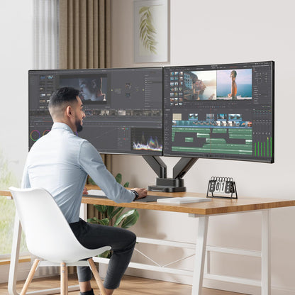 Person using dual monitor setup for video editing on 40-inch screens.