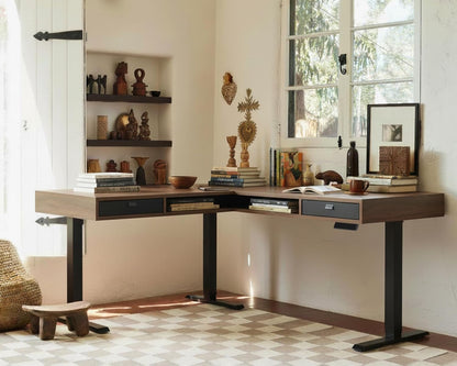 Modern L-shaped desk in a home office with decorative items and large windows.