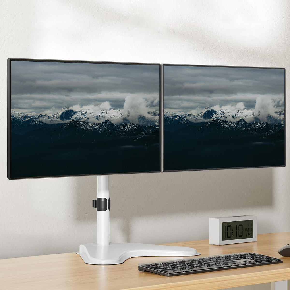 HUANUO dual monitor mount displaying two screens with a scenic mountain view.