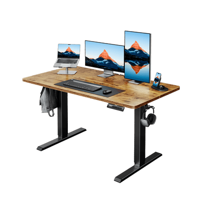 Wooden electric standing desk with laptops and monitors for ergonomic workspace.